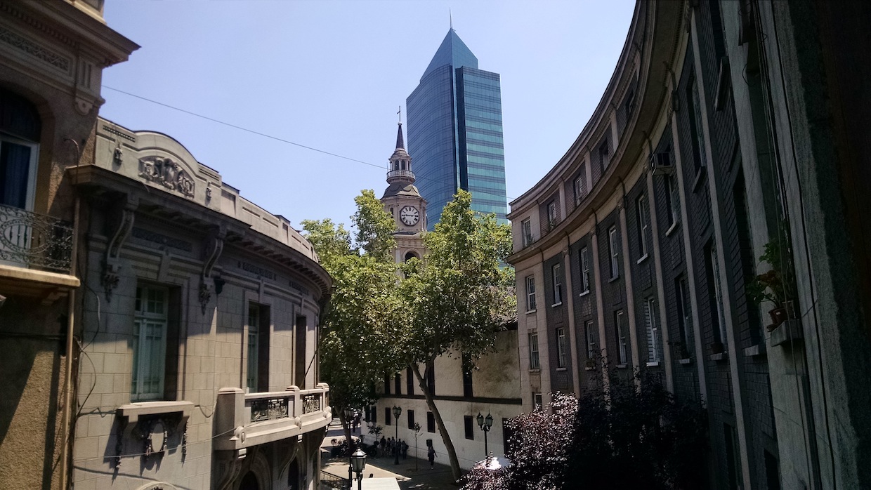 Foto com vista da arquitetura do bairro Paris-Londres em Santiago. Ao fundo, prédio comercial do centro.