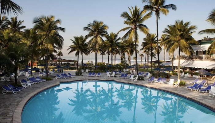 Piscina do Casa Grande Hotel Resort, com coqueiral e o mar ao fundo, em Guarujá, litoral de São Paulo