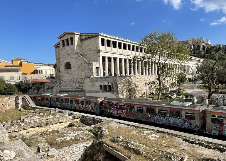 Metrô passando pelas ruínas de templo em Atenas, numa das melhores regiões da cidade, onde estão ótimos hotéis e bares.