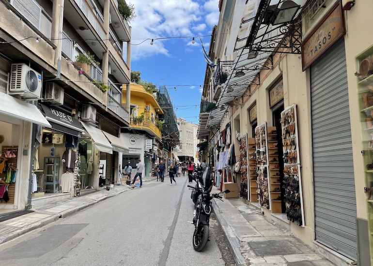 Rua em zona turística de Atenas, repleta de pousadas e lojas de presentes.